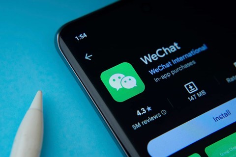 Dhaka, Bangladesh- 29 May 2025: On a blue surface, a smartphone displays the WeChat app within the