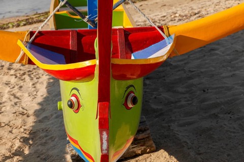 Colourfully painted outrigger fishing boats, (Junkung), on Sanur beach, Bali, Indonesia