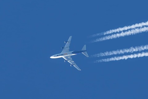 Boeing 747 jumbo jet cargo aircraft of Atlas air airlines flying in a blue sky with contrails or