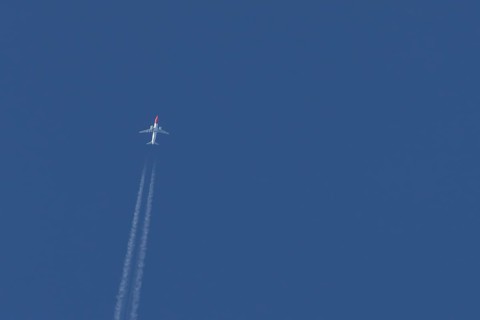 Boeing 737 jet passenger aircraft of Norwegian Air airlines flying in a blue sky with contrails or