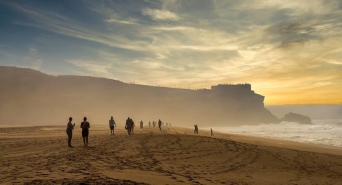 Tourists watch the waves of the Atlantic on the rocky plateau of Sito, also known as Forte São