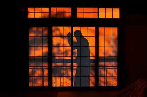Shadow of a man, burglar with knife, assassin, ninja, on the balcony behind sliding shoji doors in