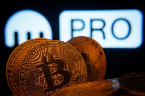 Dhaka, Bangladesh- 01 Nov 2025: Close-up of Bitcoin coins with the Kraken Pro logo visible on a