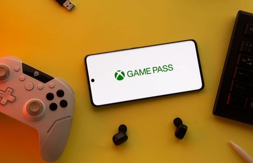 Dhaka, Bangladesh- 15 July 2025: Smartphone with Xbox game pass logo, game controller, and earbuds