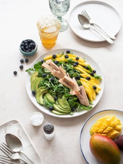 Delicious and healthy tuna salad with mango, avocado, blueberries, and lamb's lettuce, served on a