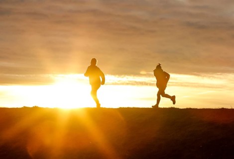 Woman and child walk across a dike on the island of Fehmarn at sunset, 13.10.2025, Fehmarn,
