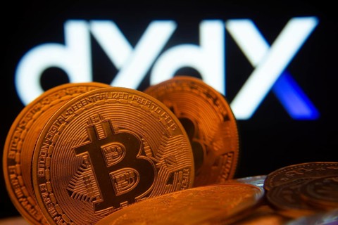 Dhaka, Bangladesh- 03 Oct 2025: Close-up of Bitcoin coins with the Dydx logo visible on a screen in
