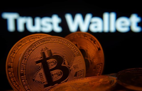 Dhaka, Bangladesh- 30 Sep 2025: Close-up of Bitcoin coins with the Trust Wallet logo visible on a