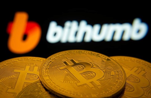 Dhaka, Bangladesh- 07 May 2025: Close-up of Bitcoin coins with the Bithumb logo visible on a screen