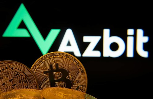 Dhaka, Bangladesh- 02 June 2025: Close-up of Bitcoin coins with the Azbit logo visible on a screen