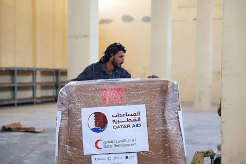 Relief workers unload boxes of medical aid provided by Qatar at Damascus International Airport,