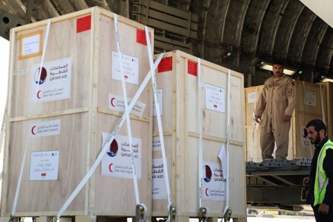 Members of the Qatari Air Force unload humanitarian aid supplies from a transport aircraft at