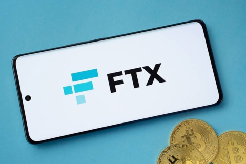 Dhaka, Bangladesh- 26 Aug 2025: FTX logo on smartphone screen near Bitcoin coin and QR code on blue