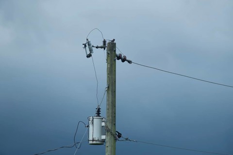 Electric pole with wires set against a cloudy, overcast sky, Gazipur, Bangladesh