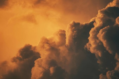 Warm orange sunset clouds with a dramatic and fluffy appearance against the sky