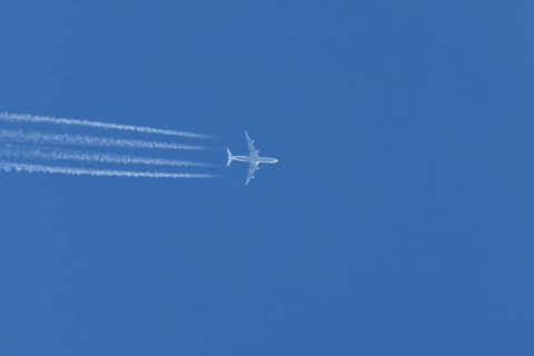 Airbus A340-300 jet aircraft of Lufthansa airlines in flight in a blue sky with vapour trails or
