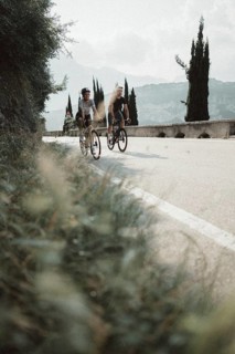 Woman and man riding racing bikes in Italy on Lake Garda