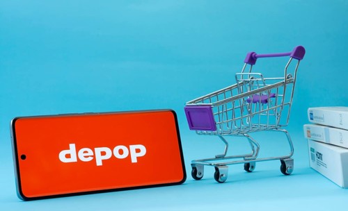 Dhaka, Bangladesh- 03 July 2025: Smartphone with Depop logo next to a small shopping cart and boxes