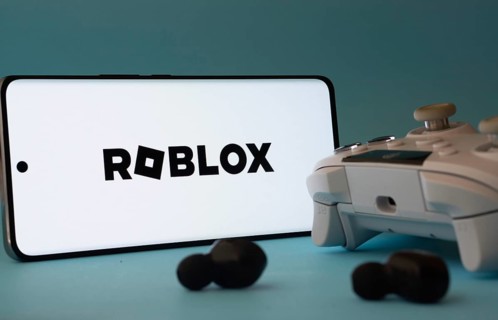 Dhaka, Bangladesh- 26 July 2025: A smartphone with a Roblox icon next to a controller and earbuds