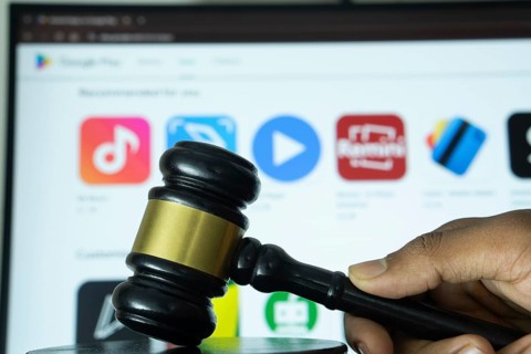 Dhaka, Bangladesh- 20 June 2025: A hand holds a gavel in front of a computer screen displaying