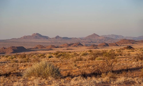 Desert landscape in the evening light at sunset, barren landscape with hills of stacked rocks,