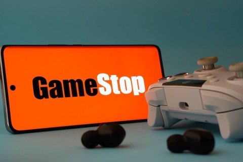 Dhaka, Bangladesh- 15 July 2025: A smartphone with a GameStop icon next to a controller and earbuds