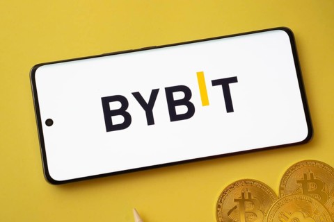 Dhaka, bangladesh- 12 July 2025: Bybit logo displayed on a smartphone with Bitcoin coins on a