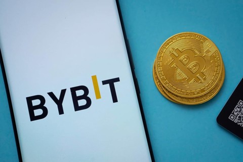 Dhaka, Bangladesh- 15 July 2025: Bybit logo on smartphone screen near Bitcoin coin and QR code on