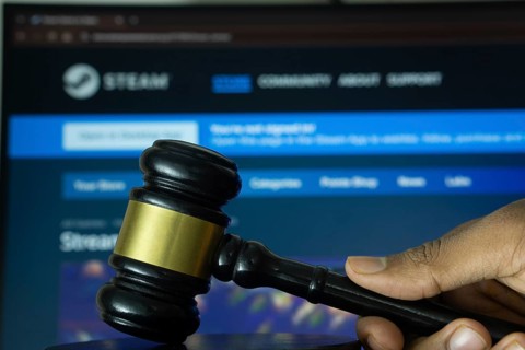 Dhaka, Bangladesh- 20 June 2025: A hand holds a gavel in front of a computer screen displaying