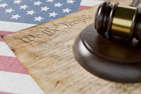 United states constitution, gavel and american flag resting on table