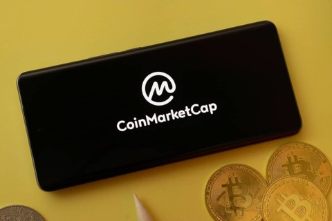 Dhaka, bangladesh- 12 June 2025: Coinmarketcap logo displayed on a smartphone with Bitcoin coins on