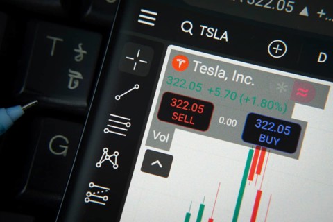 Dhaka, Bangladesh- 20 June 2025: Tesla stock trading details on smartphone over a keyboard