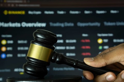 Dhaka, Bangladesh- 20 June 2025: A hand holds a gavel in front of a computer screen displaying