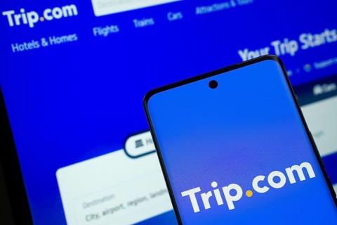 The logo of the trip.com is displayed on a smartphone screen, and the website trip.com is visible