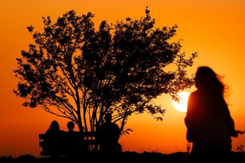 People watching the sun set on the horizon from the summit of the Großer Feldberg in the Taunus,