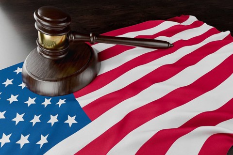American flag and wooden gavel resting on desk