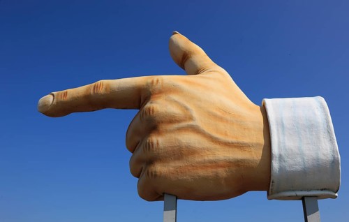 Plastic sculpture of a human hand with an outstretched index finger to indicate a direction