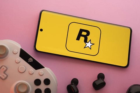 Dhaka, Bangladesh- 17 June 2025: Smartphone with rockstar games logo, game controller, and earbuds