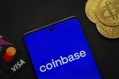 Dhaka, Bangladesh- 17 June 2025: Smartphone displaying Coinbase logo surrounded by Bitcoin coins