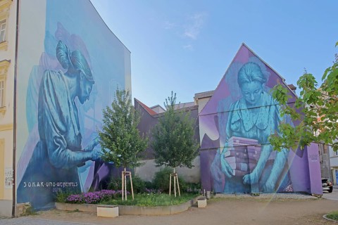 Two Mural Knowledge by Sokar Uno 2023, blue violet house wall, woman with stack of books, books,