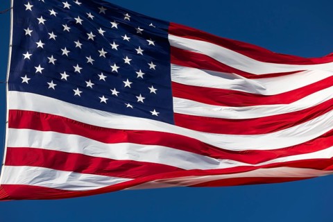 American flag waving in the wind against deep blue sky