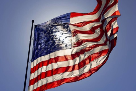 Dramatic backlit american flag waving in the wind