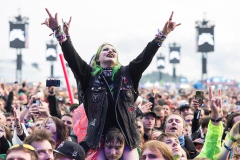 Festival visitor on shoulders with a French fries fork shaped like a hand at the Rock am Ring