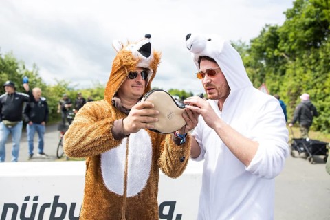 Two festival visitors in animal costumes drink from a horn at the Rock am Ring festival on Friday,