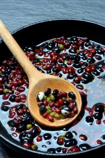 Dried beans placed in water to soak, wooden spoon