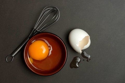 Whipped egg in small bowls, hen's egg and eggshells