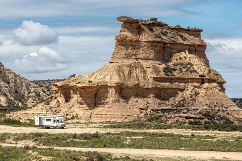 Camper van, desert, rock formation Tozal Colasico, colorful sandstone, gravel road Ruta Jubierre,