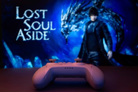 A game controller in focus with Lost Soul Aside screen in the background