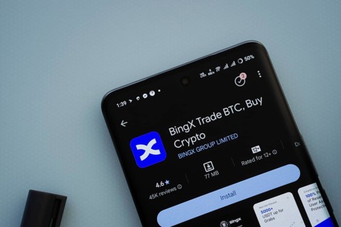 On a blue surface, a smartphone displays the BingX app within the Google Play Store