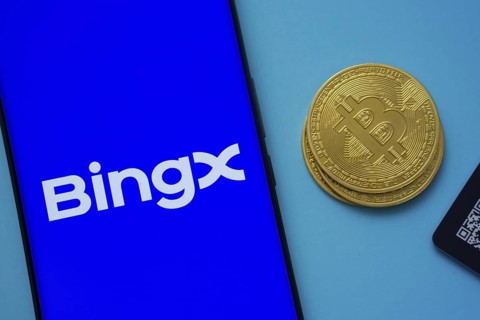 BingX logo on smartphone screen near Bitcoin coin and QR code on blue background